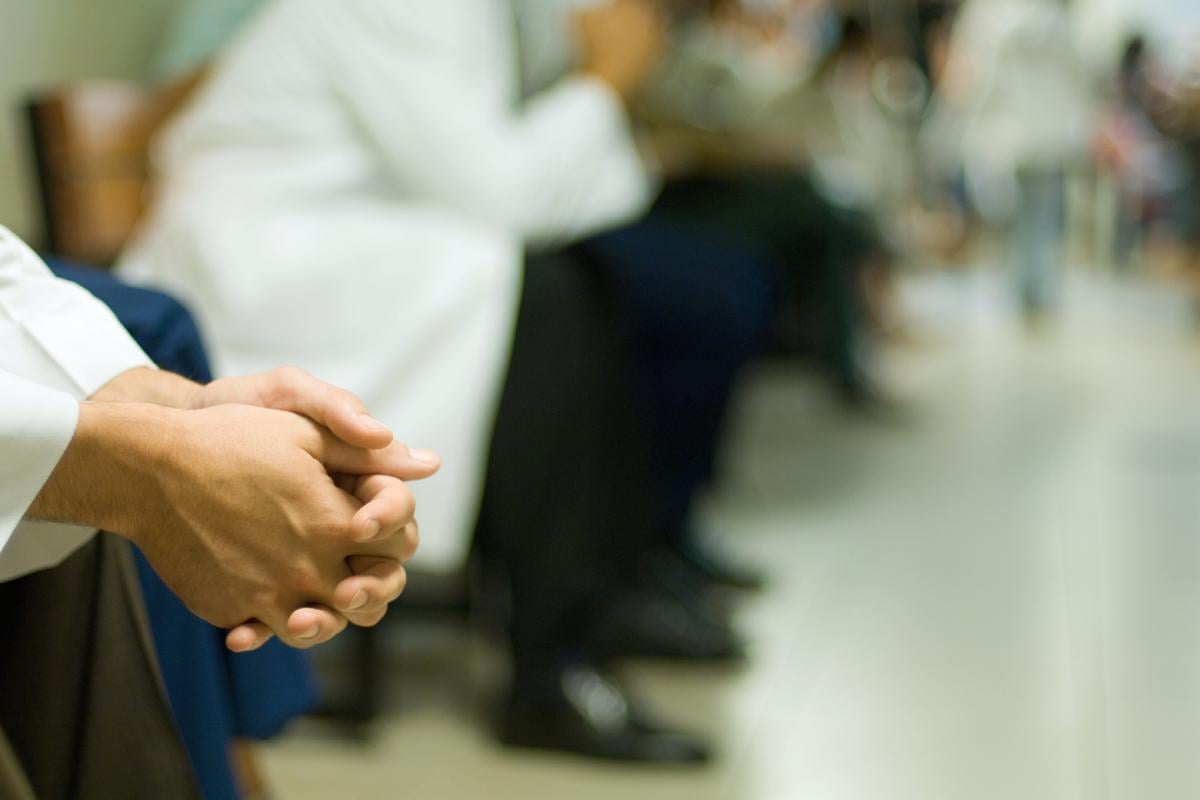 Medical professionals sitting with hands folded